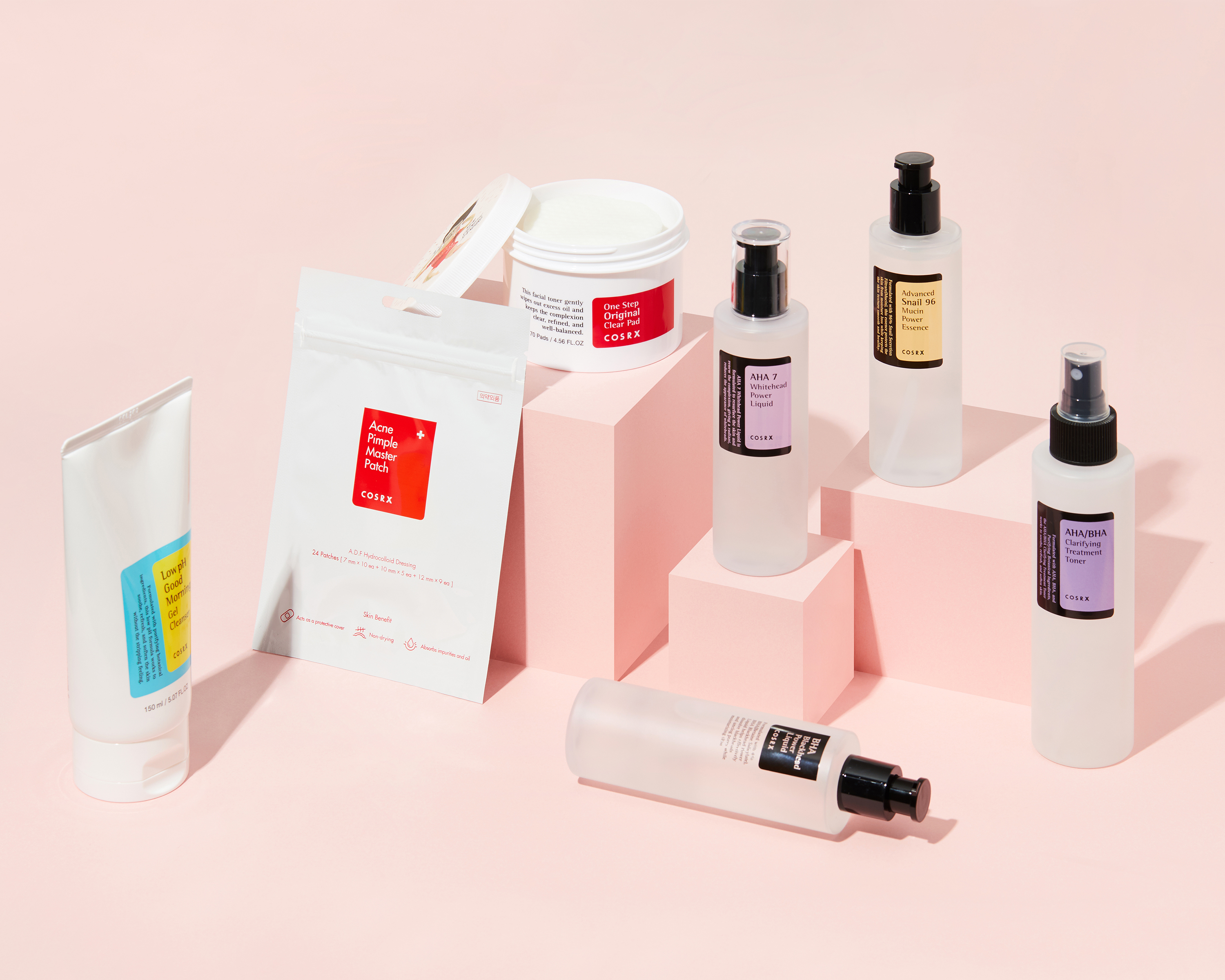 COSRX skincare collection on a soft pink background