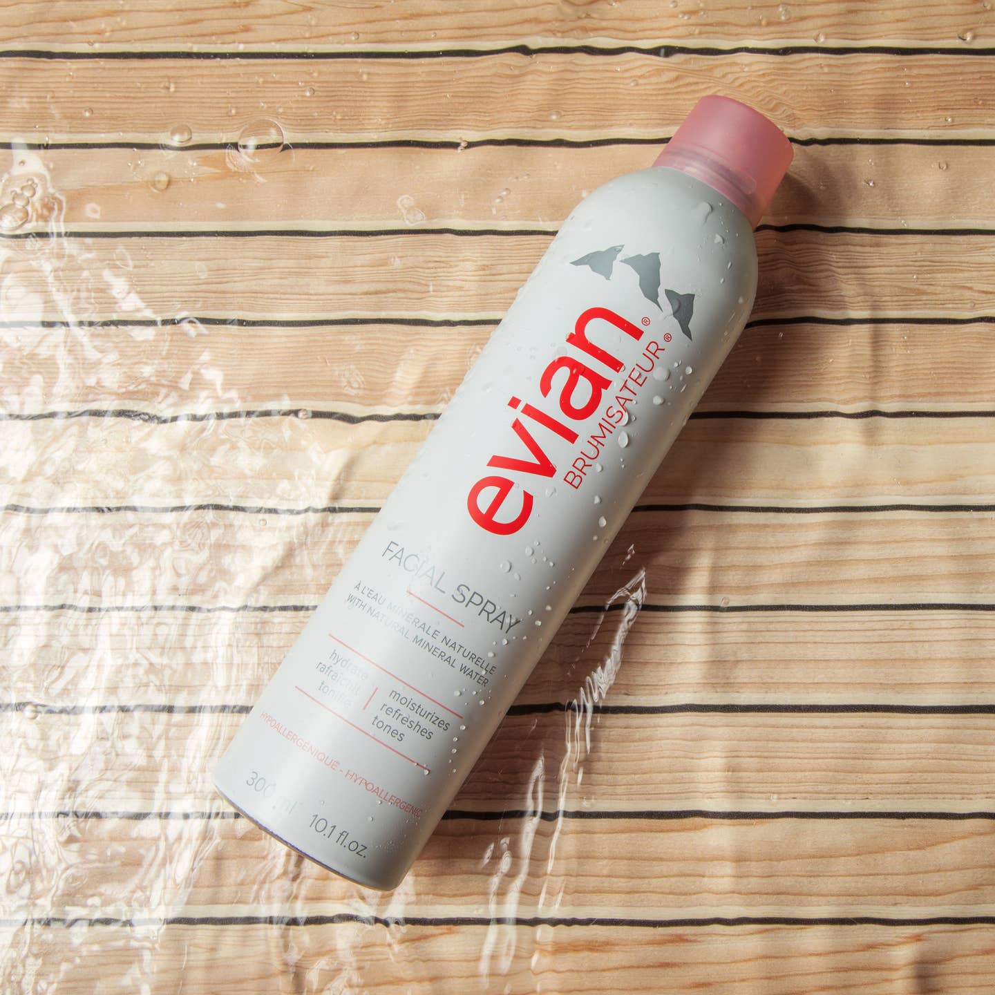 Evian Facial Spray bottle on a wooden surface