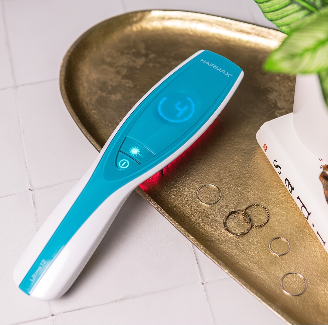 HairMax laser comb on a warm brass tray